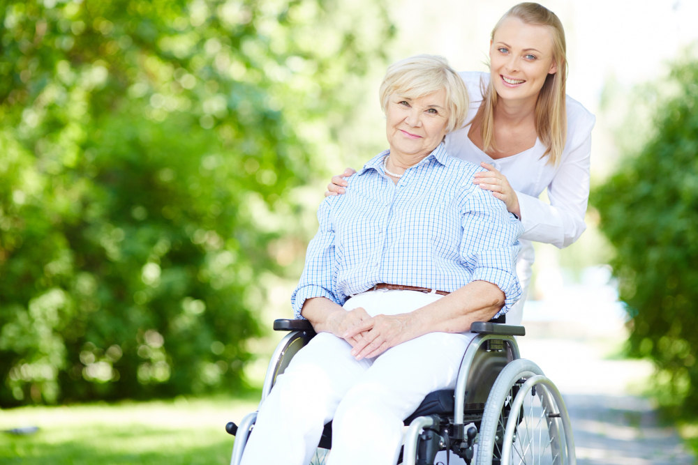 caregiver pushing senior woman wheelchair 1